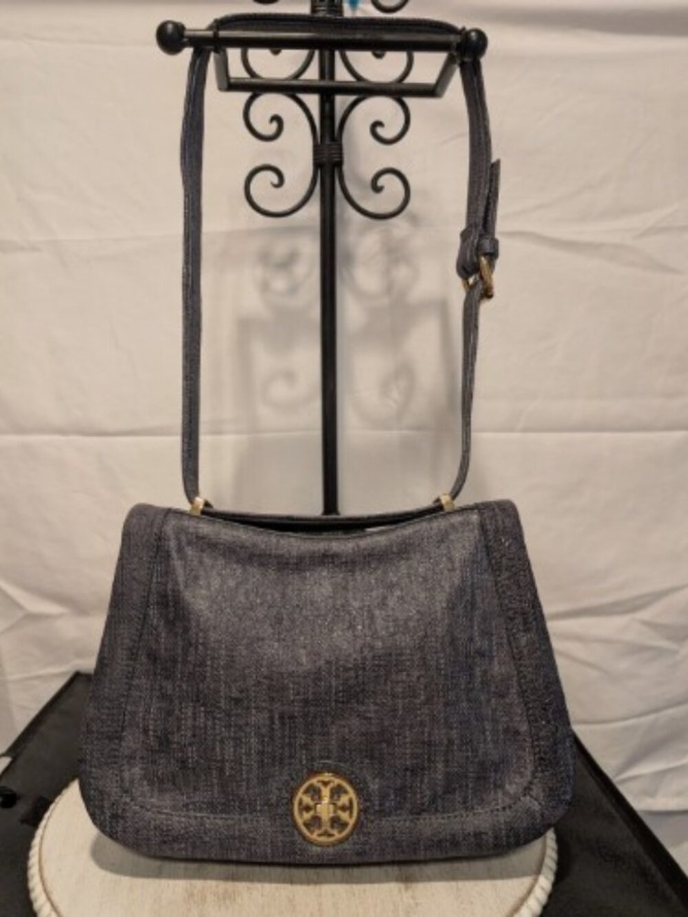 The Tory Burch Saddle Bag with Turn Lock in navy with a Brushed Denim Effect is